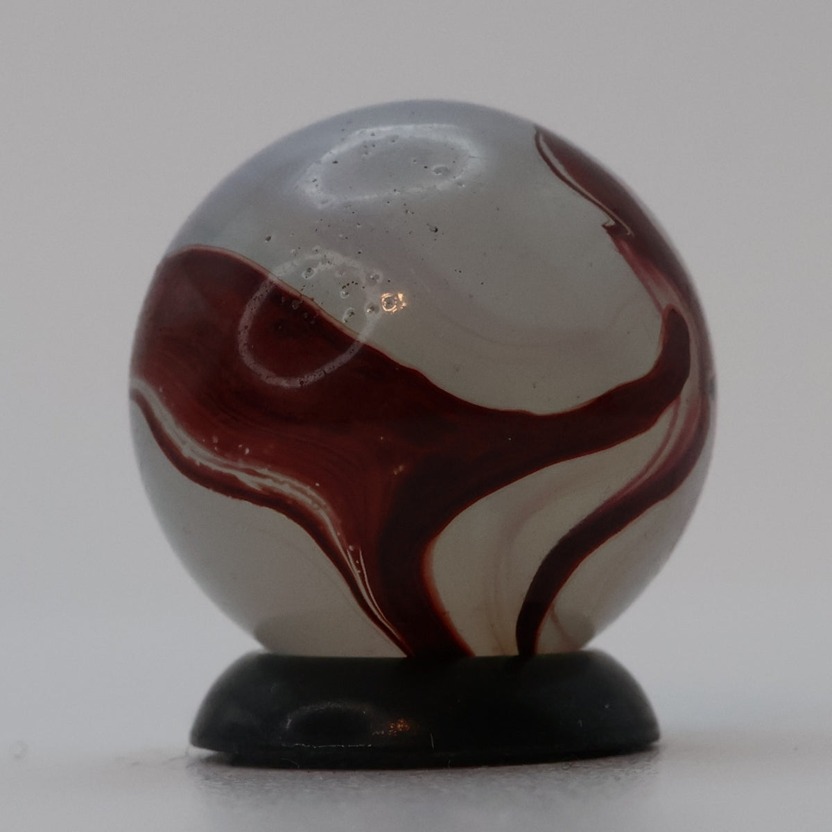 ⅝” Akro Agate Silver Oxblood NM (small pin pricks and one bigger hit)
